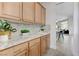 Wet bar area with wooden cabinetry, countertops, and view to living room at 2168 Big Bar Dr, Henderson, NV 89052