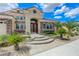 Inviting stucco home featuring stone accents, a curved entry, and lush landscaping with palm trees at 2168 Big Bar Dr, Henderson, NV 89052