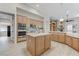 Open kitchen with wood cabinets, a center island, and stainless steel appliances at 2168 Big Bar Dr, Henderson, NV 89052