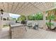 Outdoor kitchen and seating area with covered pergola and stone accents at 2168 Big Bar Dr, Henderson, NV 89052