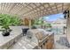 Outdoor kitchen with pergola, built-in grill, and lush tropical landscaping at 2168 Big Bar Dr, Henderson, NV 89052