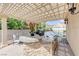 Outdoor kitchen with pergola, built-in grill, and tropical landscaping at 2168 Big Bar Dr, Henderson, NV 89052