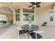 Covered patio with dining furniture, ceiling fan, and view through large glass doors into interior dining area at 2168 Big Bar Dr, Henderson, NV 89052