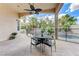 Covered patio with a dining table and chairs overlooking the pool and tropical landscaping at 2168 Big Bar Dr, Henderson, NV 89052
