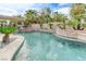 Backyard pool featuring a stone waterfall, lush tropical plants, and a shaded patio at 2168 Big Bar Dr, Henderson, NV 89052