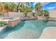 Sparkling pool with stone waterfall feature, spa, and lush landscaping creates a tranquil backyard retreat at 2168 Big Bar Dr, Henderson, NV 89052