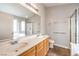 This well lit bathroom has dual sinks, tile floors, a large mirror, a stand up shower, and an enclosed toilet at 2177 Hidden Ranch Ter, Henderson, NV 89052