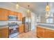 Well-lit kitchen featuring stainless steel appliances, wooden cabinetry, and tiled flooring at 2177 Hidden Ranch Ter, Henderson, NV 89052