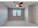 Neutral bedroom featuring a ceiling fan, two windows, and plush carpet, creating a bright and comfortable space at 23 Hudson Canyon St # 3, Henderson, NV 89012