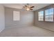 Spacious bedroom with neutral carpet, ceiling fan, and large windows offering plenty of natural light at 23 Hudson Canyon St # 3, Henderson, NV 89012