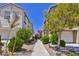 View of landscaped walkway between two-story townhouses, showcasing curb appeal and community design at 23 Hudson Canyon St # 3, Henderson, NV 89012