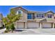 Exterior view of a three-story townhouse featuring a small balcony and a trio of garages in a contemporary style at 23 Hudson Canyon St # 3, Henderson, NV 89012