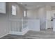 Bright hallway featuring modern gray wood floors, white railings, and natural light from the windows at 23 Hudson Canyon St # 3, Henderson, NV 89012