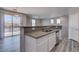 Kitchen flows into living room, stainless dishwasher, and light-filled living space with a sliding glass door to the balcony at 23 Hudson Canyon St # 3, Henderson, NV 89012