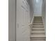 Entryway view of the carpeted staircase with white walls and a white door at 23 Hudson Canyon St # 3, Henderson, NV 89012