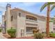 Condo building exterior featuring red tile roof, balconies, and landscaped grounds, complemented by mature palm trees under a blue sky at 2725 S Nellis Blvd # 2168, Las Vegas, NV 89121