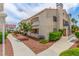 Low-rise condo with well-maintained landscaping, a red tile roof, blue railing, and multiple windows under a partly cloudy sky at 2725 S Nellis Blvd # 2168, Las Vegas, NV 89121