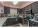 A Kitchen with stainless steel appliances, black cabinets, and contrasting countertops and backsplash is well-lit at 2725 S Nellis Blvd # 2168, Las Vegas, NV 89121