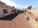 Large backyard featuring retaining walls, desert landscaping, and views of a covered patio at 2905 Shimmering Bay St, Laughlin, NV 89029