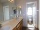 Bathroom featuring double sinks, wooden vanity, and a toilet with a view to an arch window at 2905 Shimmering Bay St, Laughlin, NV 89029