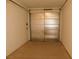View of a garage with neutral walls and floors and a metal garage door at 2905 Shimmering Bay St, Laughlin, NV 89029