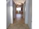 Hallway view of home showing tile floors, neutral paint and ceiling fan in the adjacent living room at 2905 Shimmering Bay St, Laughlin, NV 89029