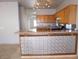 Kitchen featuring wood cabinets, tile backsplash, and breakfast bar at 2905 Shimmering Bay St, Laughlin, NV 89029