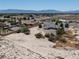 A broad view of a home with a very large lot in a desert setting with scattered trees and surrounding properties at 3451 Sagebrush Ave, Pahrump, NV 89048