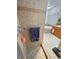 Shower with multiple shower heads, safety bars, and tile surround with decorative border. View to soaking tub at 3451 Sagebrush Ave, Pahrump, NV 89048