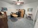 Well-lit home office with a ceiling fan, paintings, desk, cabinets, and blue carpet at 3451 Sagebrush Ave, Pahrump, NV 89048
