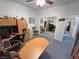 Home office with a ceiling fan, paintings, desk, cabinets, and blue carpet and mirror at 3451 Sagebrush Ave, Pahrump, NV 89048