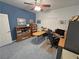 Home office with a ceiling fan, paintings, desk, cabinets, and blue carpet at 3451 Sagebrush Ave, Pahrump, NV 89048