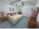 Cozy bedroom featuring a tray ceiling, ceiling fan, and wood furniture at 3451 Sagebrush Ave, Pahrump, NV 89048