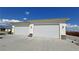 Attached two-car garage featuring stone accents and a large concrete driveway at 3451 Sagebrush Ave, Pahrump, NV 89048