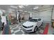 Spacious garage with a car lift, ample storage, and a modern vehicle at 3451 Sagebrush Ave, Pahrump, NV 89048