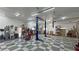 Spacious garage featuring a car lift, multiple doors, storage racks, checkered flooring, and sink at 3451 Sagebrush Ave, Pahrump, NV 89048
