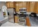 Modern kitchen with stainless steel refrigerator and appliances with wood cabinets at 3451 Sagebrush Ave, Pahrump, NV 89048