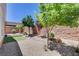 Landscaped backyard featuring gravel, trees, artificial turf, and a covered patio for relaxing outdoors at 3616 Greenbriar Bluff Ave, North Las Vegas, NV 89081