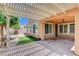 Backyard showcasing a covered patio, pergola, artificial turf, and desert landscaping at 3616 Greenbriar Bluff Ave, North Las Vegas, NV 89081