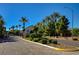 Gated community entrance featuring mature landscaping and beautiful desert trees at 3616 Greenbriar Bluff Ave, North Las Vegas, NV 89081