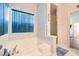 The bathroom is well-lit with a window and features a bathtub and shower at 460 Strawflower Rd, Las Vegas, NV 89107
