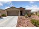 Inviting single-story home with desert landscaping, a two car garage, and stone accents at 5375 E La Campana Dr, Pahrump, NV 89061