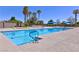 Community pool featuring ample seating, blue umbrellas, and palm tree accents at 5375 E La Campana Dr, Pahrump, NV 89061