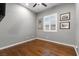 Clean bedroom featuring hardwood floors, a ceiling fan, and a window with plantation shutters at 6192 Lautman Ridge Ct, Las Vegas, NV 89141