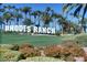 Rhodes Ranch signage surrounded by lush landscaping and palm trees at 62 Myrtle Springs Ct, Las Vegas, NV 89148