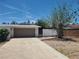 A two-car garage with ample driveway space and desert landscaping under a bright blue sky at 6215 Darby Ave, Las Vegas, NV 89146