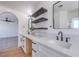 Bright bathroom featuring a double vanity, matte black hardware, and modern floating shelves at 6420 Rosemount Ave, Las Vegas, NV 89156