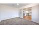 Open bedroom featuring neutral carpet and access to a kitchen with white cabinets at 6420 Rosemount Ave, Las Vegas, NV 89156
