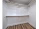 Walk-in closet with wood-look floors, white walls, and wood shelving at 6420 Rosemount Ave, Las Vegas, NV 89156