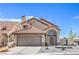 Inviting two-story home with a tile roof, arched entryway, and a well-maintained front yard with mature landscaping at 6420 Rosemount Ave, Las Vegas, NV 89156